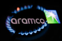 Flames from a gas burner and Aramco logo displayed on a phone screen are seen in this multiple exposure illustration photo taken in Krakow in Krakow, Poland on January 22, 2022.